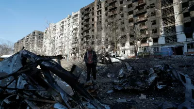 FILE PHOTO: Local resident and mechanic Vadim Tarasenko, 56, stands next to the wreckage of his car in the courtyard of an apartment building destroyed in the course of Ukraine-Russia conflict in the besieged southern port city of Mariupol, Ukraine March 28, 2022. REUTERS/Alexander Ermochenko/File Photo