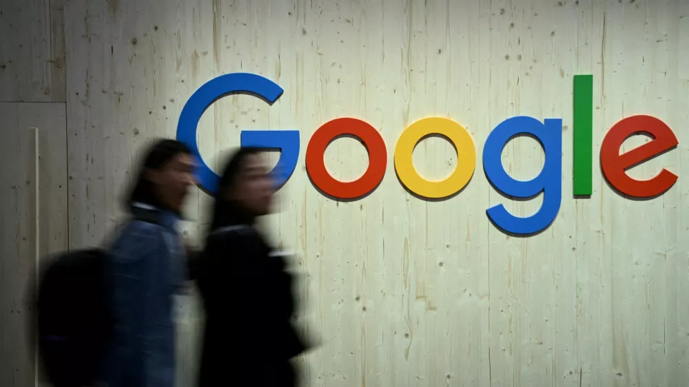 FILE PHOTO: People walk next to a Google logo during a trade fair in Hannover Messe, in Hanover, Germany, April 22, 2024. REUTERS/Annegret Hilse/File Photo