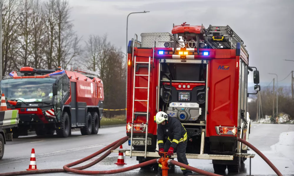 Lithuanian emergency personnel prepare to work near the site where a DHL cargo plane crashed into a house near the Lithuanian capital Vilnius, Lithuania, Monday, Nov. 25, 2024. (AP Photo/Mindaugas Kulbis)