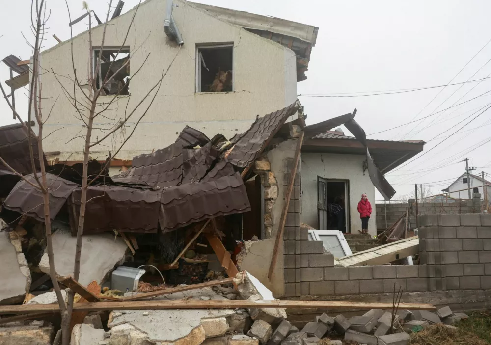 A girl stands next to her house damaged by a Russian missile strike, amid Russia's attack on Ukraine, on the outskirts of Odesa, Ukraine November 28, 2024. REUTERS/Nina Liashonok   TPX IMAGES OF THE DAY