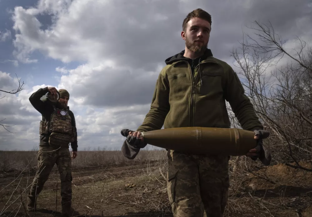 FILE - Ukrainian soldiers carry shells to fire at Russian positions on the front line, near the city of Bakhmut, in Ukraine's Donetsk region, on March 25, 2024. (AP Photo/Efrem Lukatsky, File)