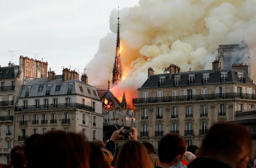 FILE PHOTO: Smoke billows as fire engulfs the spire of Notre Dame Cathedral in Paris, France, April 15, 2019. Picture taken April 15, 2019. REUTERS/Benoit Tessier/File Photo