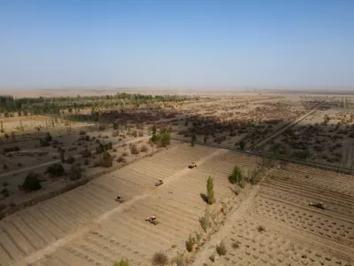 FILE PHOTO: Wheel loaders move soil to prepare a field for tree planting, at one of the sections of the Yangguan state-backed forest farm, on the edge of the Gobi desert, on the outskirts of Dunhuang, Gansu province, China, April 13, 2021. REUTERS/Carlos Garcia Rawlins/File Photo