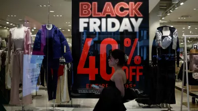 FILE PHOTO: A shopper walks past an advertisement for Black Friday sales displayed in a store window at Pentagon City in Arlington, Virginia, U.S., November 27, 2024. REUTERS/Benoit Tessier/File Photo