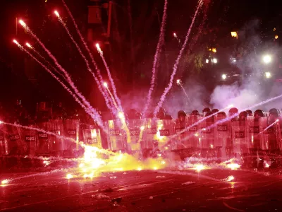 Demonstrators use firecrackers against police during a rally against the government's decision to suspend negotiations on joining the European Union for four years, outside the parliament's building in Tbilisi, Georgia, early Sunday, Dec. 1, 2024. (AP Photo/Zurab Tsertsvadze)