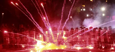 Demonstrators use firecrackers against police during a rally against the government's decision to suspend negotiations on joining the European Union for four years, outside the parliament's building in Tbilisi, Georgia, early Sunday, Dec. 1, 2024. (AP Photo/Zurab Tsertsvadze)