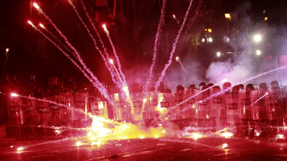 Demonstrators use firecrackers against police during a rally against the government's decision to suspend negotiations on joining the European Union for four years, outside the parliament's building in Tbilisi, Georgia, early Sunday, Dec. 1, 2024. (AP Photo/Zurab Tsertsvadze)