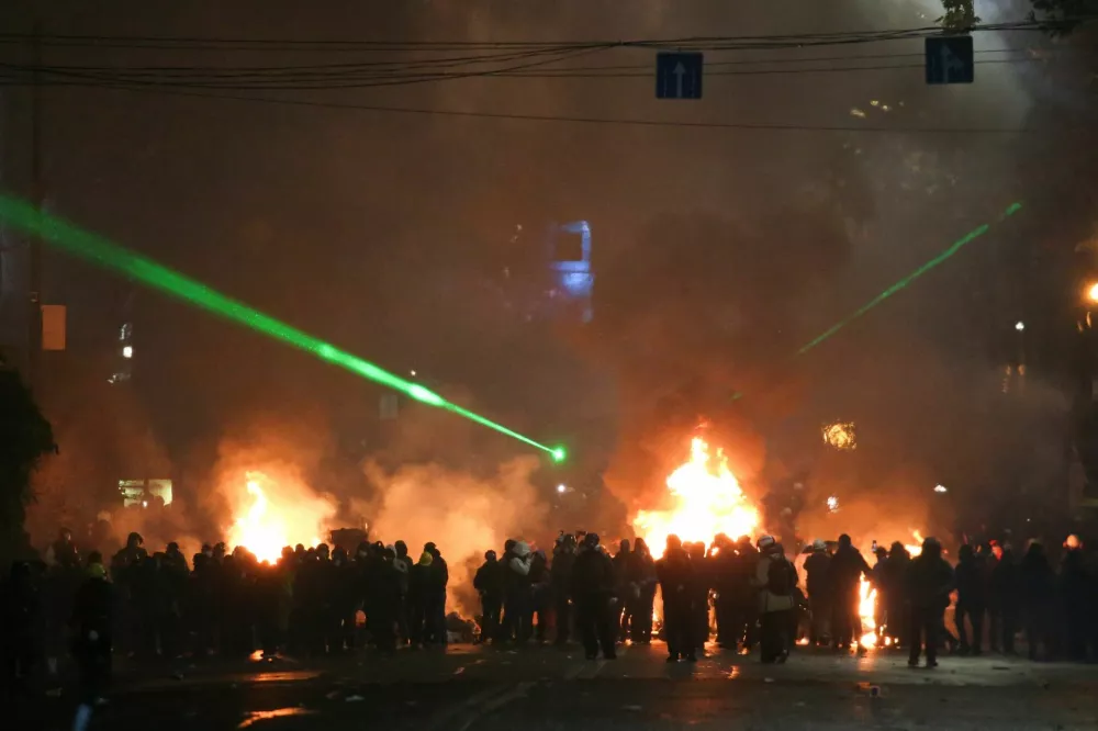 Demonstrators stand next to a fire during a protest against the new government's decision to suspend the European Union accession talks and refuse budgetary grants until 2028, in Tbilisi, Georgia December 2, 2024. REUTERS/Irakli Gedenidze