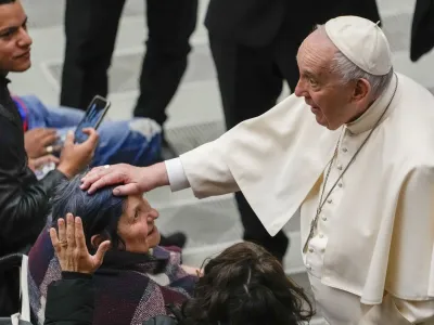 Pope Francis greets faithful at the end of his weekly general audience in the Paul VI Hall, at the Vatican, Wednesday, April 6, 2022. (AP Photo/Alessandra Tarantino)