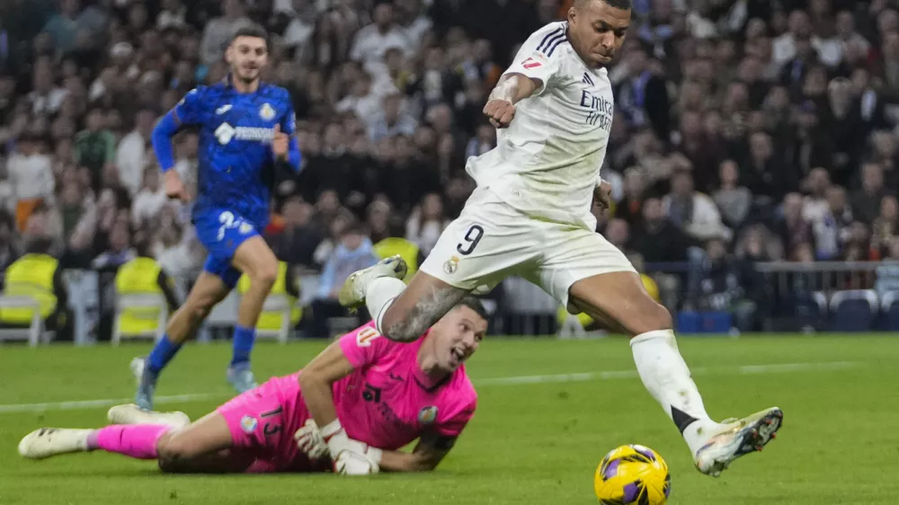 Real Madrid's Kylian Mbappe kicks the ball in an attempt to score during the Spanish La Liga soccer match between Real Madrid and Getafe at the Santiago Bernabeu Stadium in Madrid, Spain, Sunday, Dec. 1, 2024. (AP Photo/Bernat Armangue)