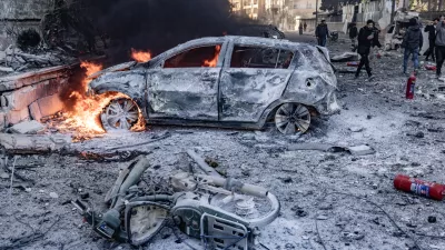 02 December 2024, Syria, Idlib: Vehicles burn while people inspect the damage caused by a Russian air strike on Idlib University. At least 11 people, including five children, were killed when Syrian and Russian warplanes launched a series of air strikes on rebel-held areas in north-western Syria on Monday, activists and a monitor group said. Photo: Anas Alkharboutli/dpa