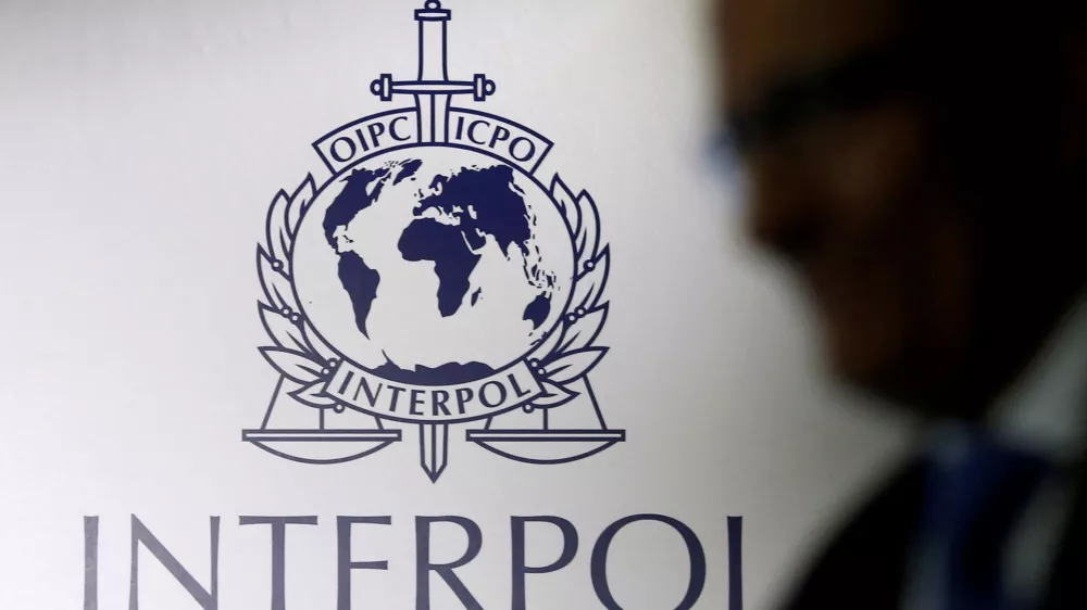 FILE PHOTO: A man passes an Interpol logo during the handing over ceremony of the new premises for Interpol's Global Complex for Innovation, a research and development facility, in Singapore September 30, 2014. REUTERS/Edgar Su//File Photo