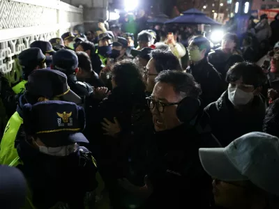 People react as police close the gate of the National Assembly, after South Korean President Yoon Suk Yeol declared martial law, in Seoul, South Korea, December 4, 2024. REUTERS/Kim Hong-Ji