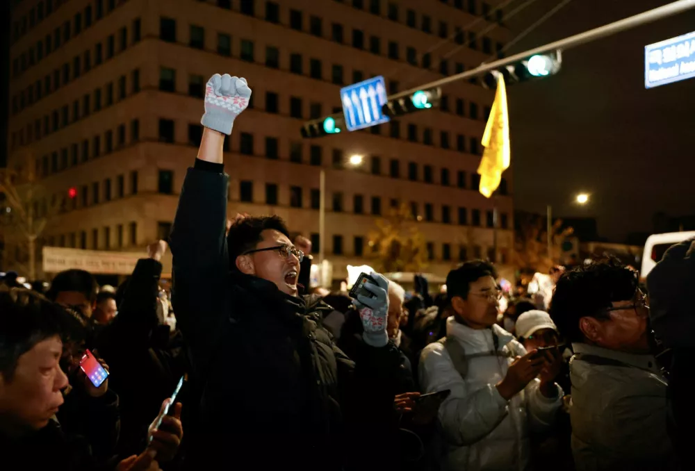 A person gestures while standing among the crowd outside the National Assembly, after South Korean President Yoon Suk Yeol declared martial law, in Seoul, South Korea, December 4, 2024. REUTERS/Kim Soo-hyeon