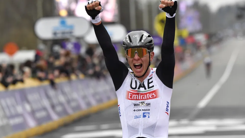 Slovenia's Tadej Pogacar of the UAE Team Emirates celebrates as he crosses the finish line to win the Tour of Flanders in Oudenaarde, Belgium on Sunday, April 2, 2023. (AP Photo/Geert Vanden Wijngaert)