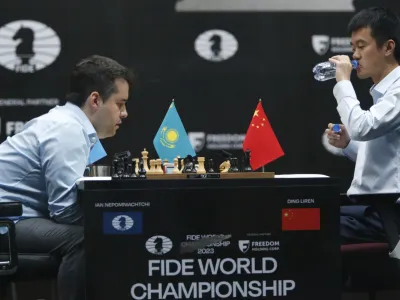 China's Ding Liren, right, drinks water as Russia's Ian Nepomniachtchi plays during their tiebreaker of FIDE World Chess Championship in Astana, Kazakhstan, Sunday, April 30, 2023. (AP Photo/Stanislav Filippov)