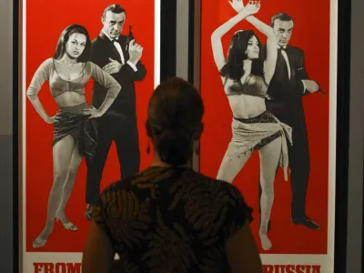 A member of the media is seen in front of James Bond posters on display at the "For Your Eyes Only, Ian Fleming and James Bond" exhibition at the Imperial War Museum in London, Wednesday, April 16, 2008. The exhibition, which opens on Thursday, is to celebrate the centenary of Ian Fleming's birth and is the first major exhibition devoted to the life and work of the man who created the world's most famous secret agent, James Bond. (AP Photo/Matt Dunham)