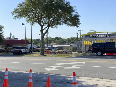 Police vehicles sit parked in front of a McDonald's restaurant as police investigate a shooting in which multiple people were killed Thursday, May 4, 2023, in Moultrie, Ga. The Georgia Bureau of Investigation said Thursday that there is more than one crime scene, including one at the McDonald's restaurant. (Kamira Smith/The Moultrie Observer via AP)