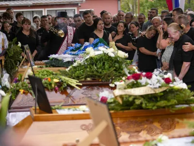 Orthodox priests attend a funeral for five people killed during the second mass shooting in two days, in the village of Malo Orasje, some 50 kilometers (30 miles) south of Belgrade, Serbia, Saturday, May 6, 2023. In Thursday's attack, a 20-year-old gunman apparently firing at random killed eight people and wounded 14 in two Serbian villages. (AP Photo/Darko Vojinovic)