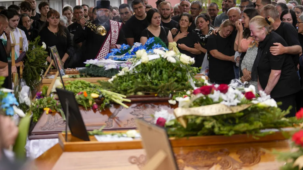 Orthodox priests attend a funeral for five people killed during the second mass shooting in two days, in the village of Malo Orasje, some 50 kilometers (30 miles) south of Belgrade, Serbia, Saturday, May 6, 2023. In Thursday's attack, a 20-year-old gunman apparently firing at random killed eight people and wounded 14 in two Serbian villages. (AP Photo/Darko Vojinovic)