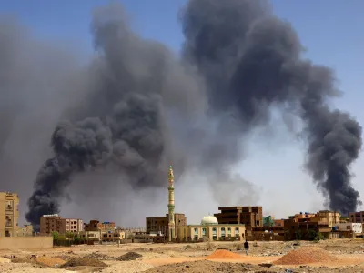 FILE PHOTO: A man walks while smoke rises above buildings after aerial bombardment, during clashes between the paramilitary Rapid Support Forces and the army in Khartoum North, Sudan, May 1, 2023. REUTERS/Mohamed Nureldin Abdallah/File Photo