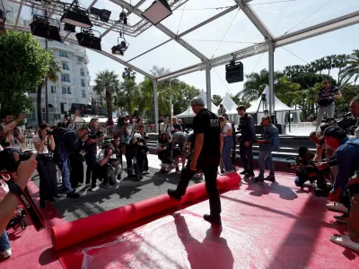 The 76th Cannes Film Festival - Red carpet installation - Cannes, France, May 16, 2023. Photographers take photos as workers install the red carpet in front of the main entrance of the Festival Palace before the opening ceremony. REUTERS/Gonzalo Fuentes