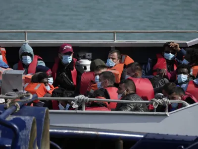 People thought to be migrants who undertook the crossing from France in small boats and were picked up in the Channel, wait to be disembarked from a British border force vessel, in Dover, south east England, Friday, June 17, 2022. The British government vowed Wednesday to organize more flights to deport asylum-seekers from around the world to Rwanda, after a last-minute court judgment grounded the first plane due to take off under the contentious policy. (AP Photo/Matt Dunham)