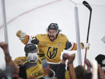 Vegas Golden Knights wing Mark Stone celebrates with Brett Howden, obscured at lower left, who scored in overtime against the Dallas Stars during Game 1 of the NHL hockey Stanley Cup Western Conference finals Friday, May 19, 2023, in Las Vegas. The Golden Knights won 4-3. (AP Photo/Sam Morris)