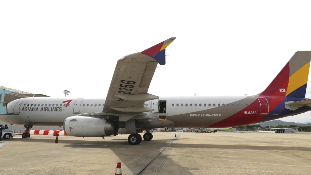 An Asiana Airlines plane is parked as one of the plane's doors suddenly opened at Daegu International Airport in Daegu, South Korea, Friday, May 26, 2023. A passenger opened a door on an Asiana Airlines flight that later landed safely at a South Korean airport Friday, airline and government officials said. (Yun Kwan-shick/Yonhap via AP)