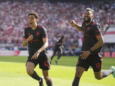 Bayern's Jamal Musiala, left, celebrates with Bayern's Eric Maxim Choupo-Moting after scoring his side's second goal during the German Bundesliga soccer match between 1.FC Cologne and FC Bayern Munich in Cologne, Germany, Saturday, May 27, 2023. (AP Photo/Matthias Schrader)