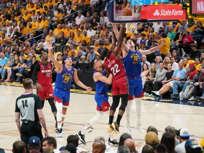 Jun 1, 2023; Denver, CO, USA; Miami Heat forward Jimmy Butler (22) shoots the ball against Denver Nuggets forward Michael Porter Jr. (left) and center Nikola Jokic (15) during the second half in game one of the 2023 NBA Finals at Ball Arena. Mandatory Credit: Kyle Terada-USA TODAY Sports