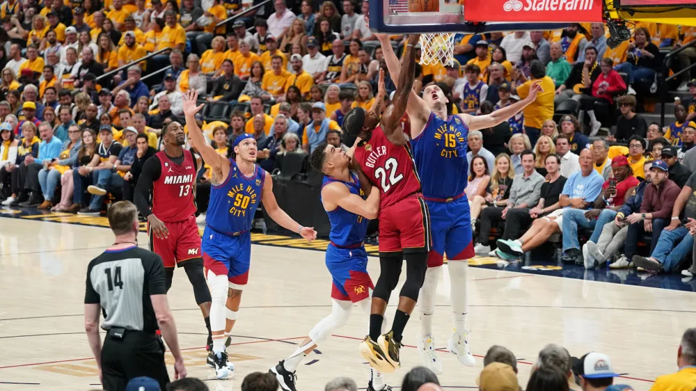 Jun 1, 2023; Denver, CO, USA; Miami Heat forward Jimmy Butler (22) shoots the ball against Denver Nuggets forward Michael Porter Jr. (left) and center Nikola Jokic (15) during the second half in game one of the 2023 NBA Finals at Ball Arena. Mandatory Credit: Kyle Terada-USA TODAY Sports