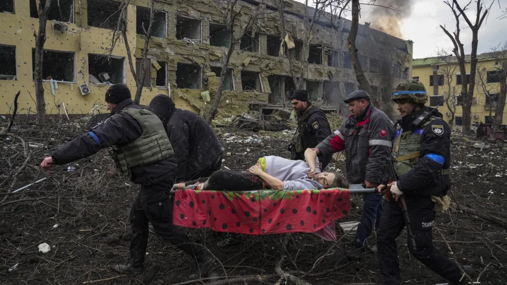 FILE - Ukrainian emergency employees and police officers evacuate injured pregnant woman Iryna Kalinina, 32, from a maternity hospital that was damaged by a Russian airstrike in Mariupol, Ukraine, March 9, 2022. The award-winning film "20 Days in Mariupol" got its premiere in Ukraine on Saturday, June 3, 2023, attended by some Ukrainian medics and security officials who got their first look at the jarring documentary on how Russian forces bombed and blasted their way into the southeastern port city last year. (AP Photo/Evgeniy Maloletka, File)