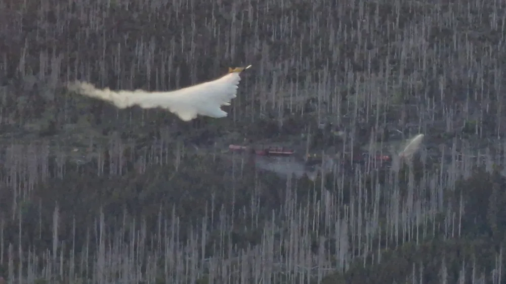 04 June 2023, Lower Saxony, Schierke: A firefighting aircraft drops water for firefighting over the area around the Brocken mountain. Photo: Cevin Dettlaff/dpa-Zentralbild/dpa