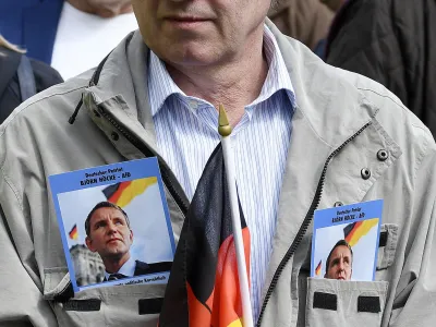 ﻿File---File picture taken May 1, 2019 shows a supporter of Alternative for Germany party AfD waiting for the beginning of a rally in Erfurt, Germany. Flyers in jacket show leader of Thuringia's AfD faction Bjoern Hoecke. German media outlets are reporting the country's domestic intelligence agency has put the opposition Alternative for Germany party under observation under suspicion of extreme right sympathies. (AP Photo/Jens Meyer, file)