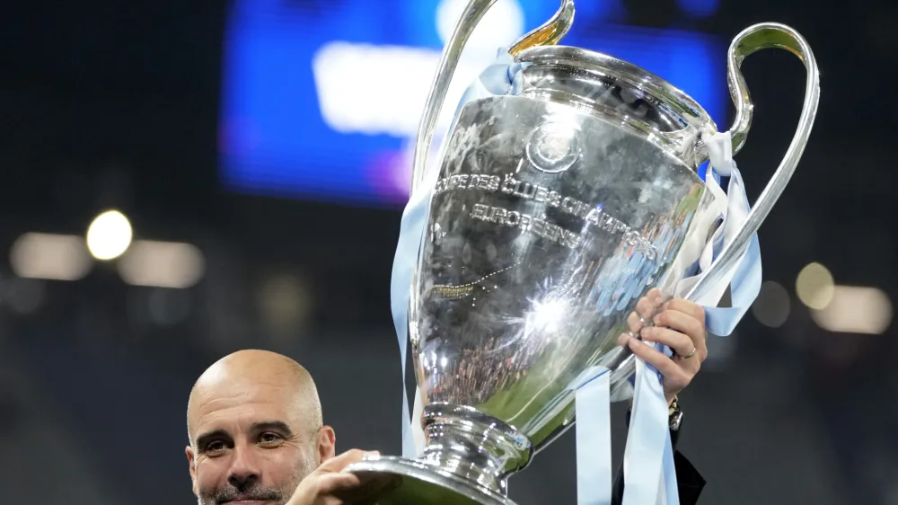 Manchester City's head coach Pep Guardiola holds the trophy after winning the Champions League final soccer match between Manchester City and Inter Milan at the Ataturk Olympic Stadium in Istanbul, Turkey, Sunday, June 11, 2023. Manchester City won 1-0. (AP Photo/Francisco Seco)