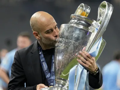 Manchester City's head coach Pep Guardiola kisses the trophy after winning the Champions League final soccer match between Manchester City and Inter Milan at the Ataturk Olympic Stadium in Istanbul, Turkey, Sunday, June 11, 2023. Manchester City won 1-0. (AP Photo/Francisco Seco)