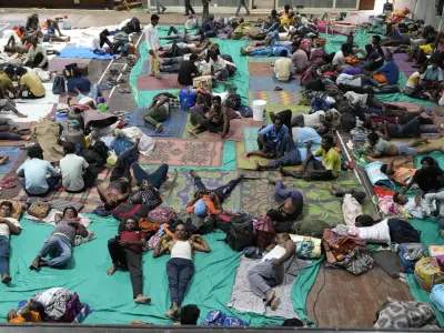 People evacuated from Kandla port, in preparation of Cyclone Biparjoy, rest at a shelter in Gandhidham, India, Tuesday, June 13, 2023. India and Pakistan braced for the first severe cyclone this year expected to hit their coastal regions later this week, as authorities on Monday halted fishing activities, deployed rescue personnel and announced evacuation plans for those at risk. (AP Photo/Ajit Solanki)