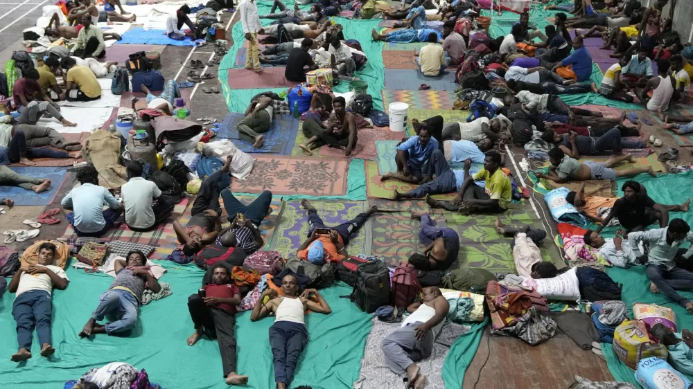 People evacuated from Kandla port, in preparation of Cyclone Biparjoy, rest at a shelter in Gandhidham, India, Tuesday, June 13, 2023. India and Pakistan braced for the first severe cyclone this year expected to hit their coastal regions later this week, as authorities on Monday halted fishing activities, deployed rescue personnel and announced evacuation plans for those at risk. (AP Photo/Ajit Solanki)