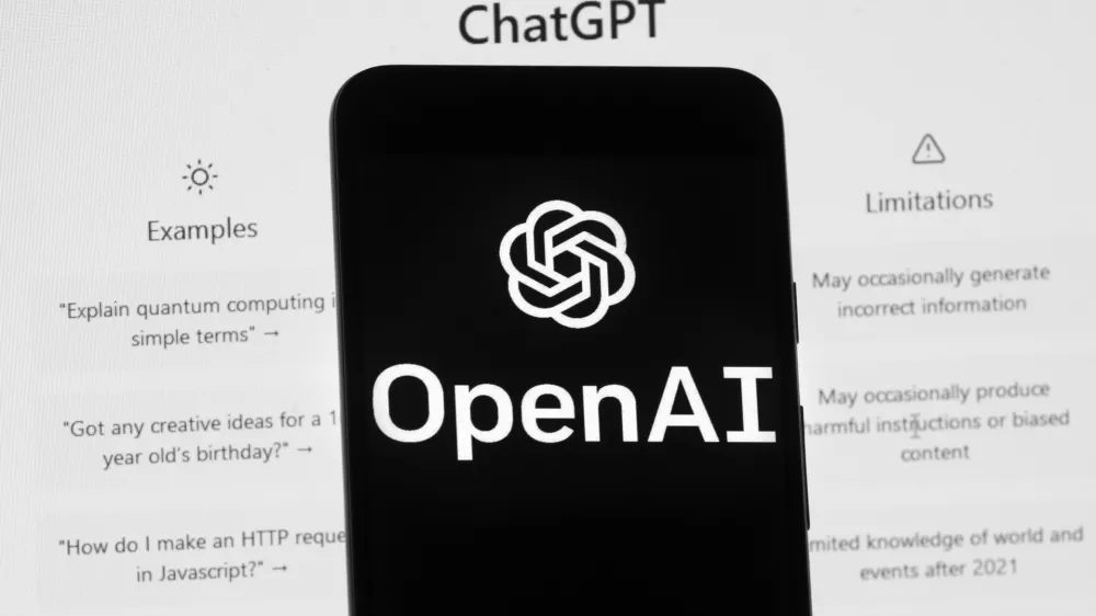 FILE - The OpenAI logo is seen on a mobile phone in front of a computer screen displaying the ChatGPT home screen, March 17, 2023, in Boston. Chinese police said they recently detained a ChatGPT user for allegedly using the AI-powered chatbot to create a fake news story about a nonexistent train crash. (AP Photo/Michael Dwyer, File)