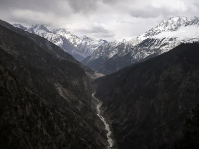 FILE - The Sutlej River flows in the valley below the tall snowy peaks in the Kinnaur district of the Himalayan state of Himachal Pradesh, India, March 13, 2023. A new report Tuesday, June 20, from a Nepal-based research organization finds that water security for nearly 2 billion people living downstream of rivers that originate in the Himalayan ranges will likely be threatened by the end of this century due to rapid glacier melt if global warming is not controlled. (AP Photo/Ashwini Bhatia, File)