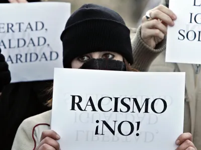 Demonstrators gather during an anti-racism protest in Alcorcon, a suburb of Madrid, Saturday Jan. 27, 2007, a week after a street battle between Spanish and immigrant gangs which ended with seven arrested and at least four injured. Minor street disturbances again took place Saturday evening with police continuously dispersing groups of stone throwing youths. Placard reads: 'Racism, No' (AP Photo/Paul White)