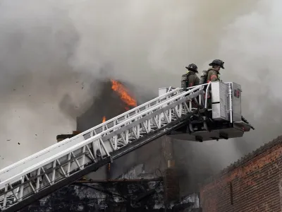 FILE - Buffalo firefighters adjust their approach from above at a massive blaze that claimed the life of Buffalo Firefighter Jason Arno on March 1, 2023, in Buffalo, N.Y. The explosive fire in a Buffalo costume shop where a firefighter became trapped and died has been ruled accidental and no criminal charges will be filed, a prosecutor said Thursday, July 6, 2023. (Derek Gee/The Buffalo News via AP, File)