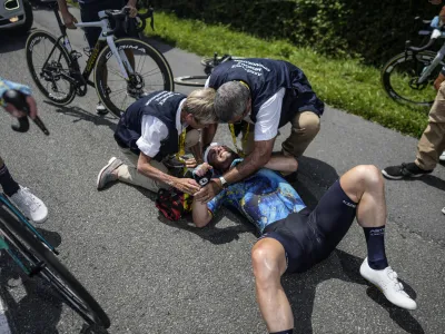 Britain's Mark Cavendish receives medical assistance after crashing during the eighth stage of the Tour de France cycling race over 201 kilometers (125 miles) with start in Libourne and finish in Limoges, France, Saturday, July 8, 2023. (AP Photo/Thibault Camus)