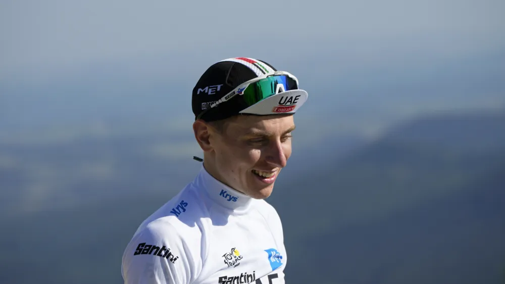 Slovenia's Tadej Pogacar, wearing the best young rider's white jersey, smiles on the podium of the ninth stage of the Tour de France cycling race over 182.5 kilometers (113.5 miles) with start in Saint-Leonard-de-Noblat and finish in Puy de Dome, France, Sunday, July 9, 2023. (AP Photo/Daniel Cole)