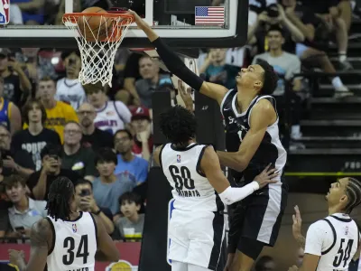 San Antonio Spurs' Victor Wembanyama dunks over Portland Trail Blazers' Justin Minaya during the first half of an NBA summer league basketball game Sunday, July 9, 2023, in Las Vegas. (AP Photo/John Locher)