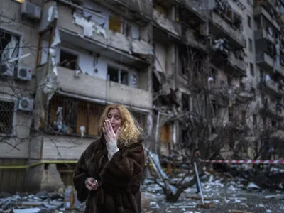 FILE - Natali Sevriukova reacts next to her house following a rocket attack the city of Kyiv, Ukraine, on Feb. 25, 2022. With Russia's war on Ukraine in its 17th month and Western countries sending increasingly hi-tech and long-range weapons and ammunition to help President Volodymyr Zelenskyy defend his country, it's easy to lose track of where NATO stands. (AP Photo/Emilio Morenatti, File)