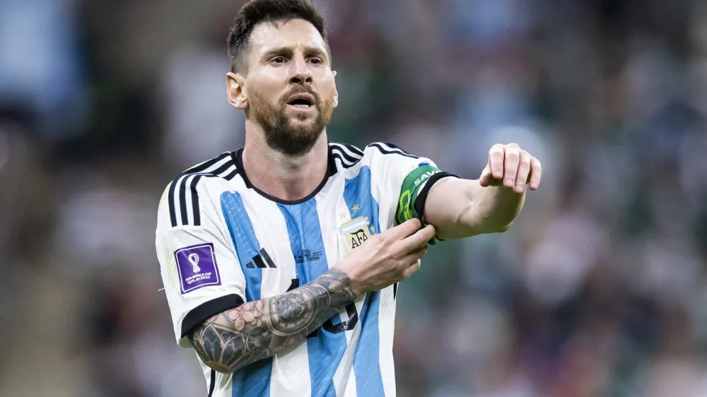 FILED - 26 November 2022, Qatar, Lusail: Argentina's Lionel Messi pushes up his captain's armband. World Cup champion Lionel Messi is feeling ready for his new life in the United States following a transfer from Paris Saint-Germain to Inter Miami. Photo: Tom Weller/dpa