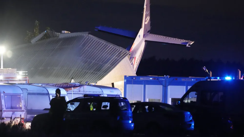 The tail of a Cessna 208 plane sticks out of a hangar after it crashed there in bad weather killing several people and injuring others, at a sky-diving centre in Chrcynno, central Poland, on Monday, July 17, 2023. (AP Photo/Czarek Sokolowski)