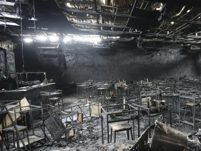 Major fire damage fills the interior at the Mountain B pub in the Sattahip district of Chonburi province, about 160 kilometers (100 miles) southeast of Bangkok, Thailand. Over a dozen people were killed and dozens injured when a fire broke out early Friday morning at the crowded music pub, police and rescue workers said. (AP Photo/Anuthep Cheysakron)